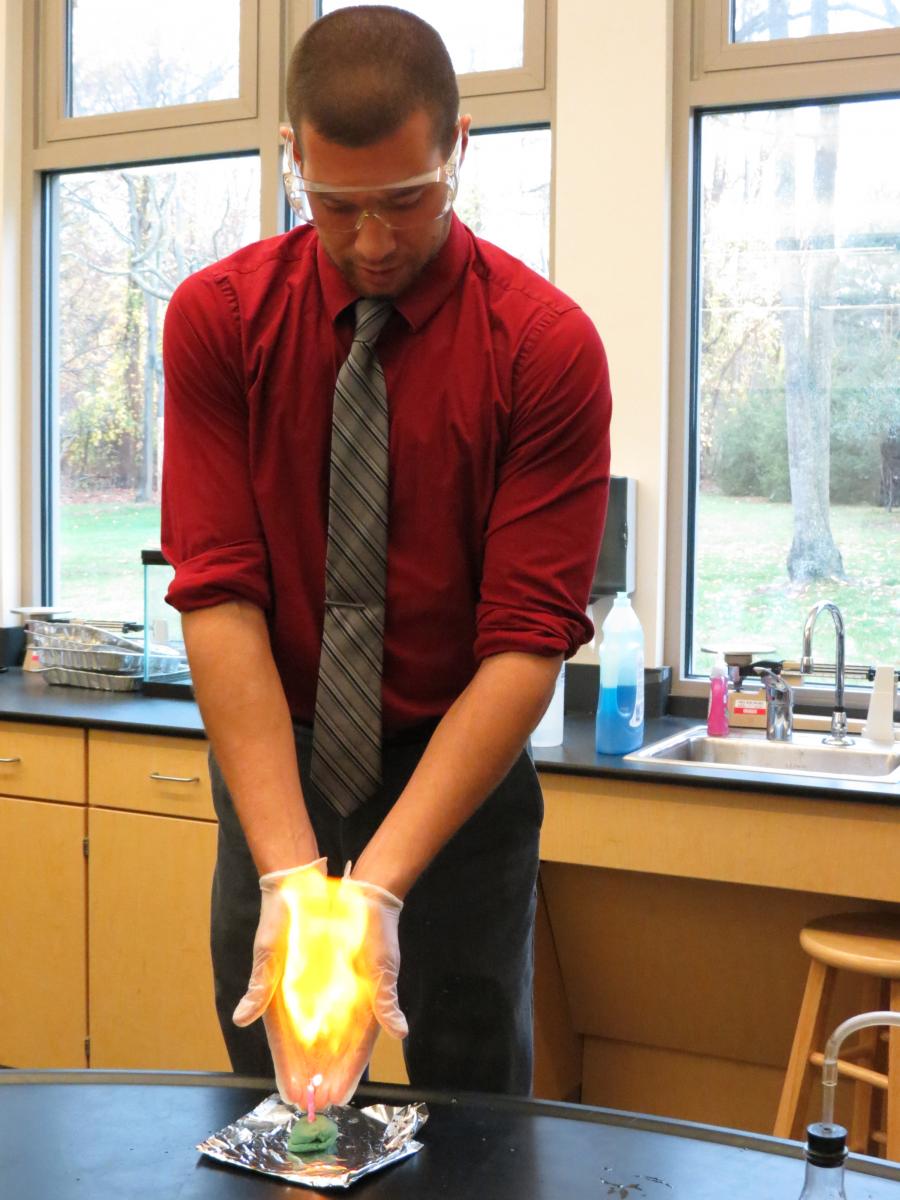 Male student taking part in a science experiment at our Upper School